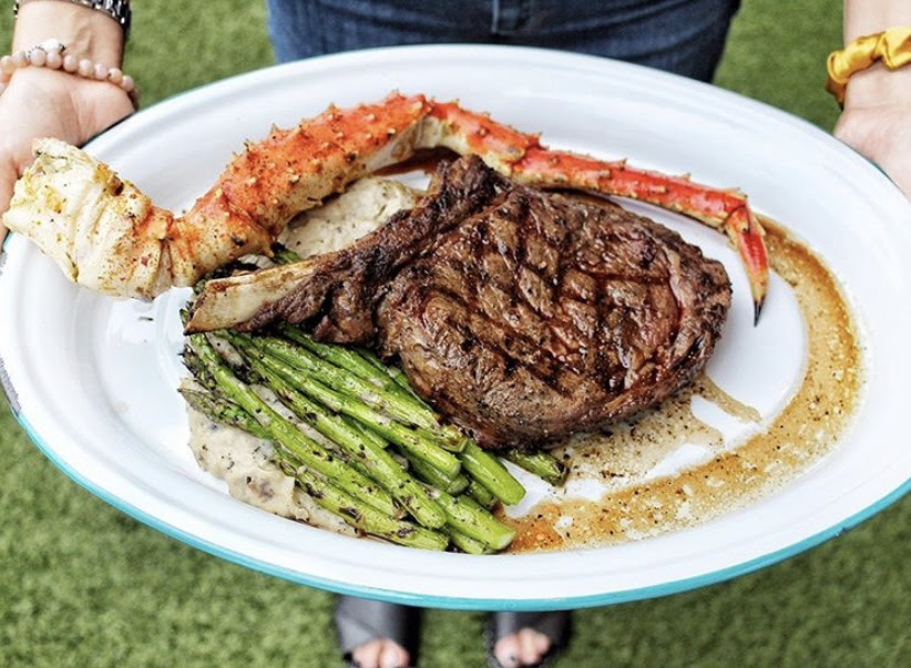 Bone-in cowboy ribeye with king crab and asparagus